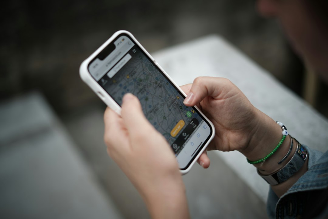 Seseorang memegang ponsel pintar untuk memeriksa lokasi GPS pelacak kendaraan
